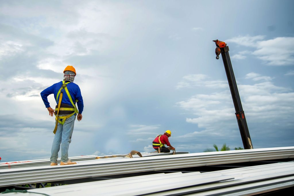 Two kokua roofing workers together on a commercial job.