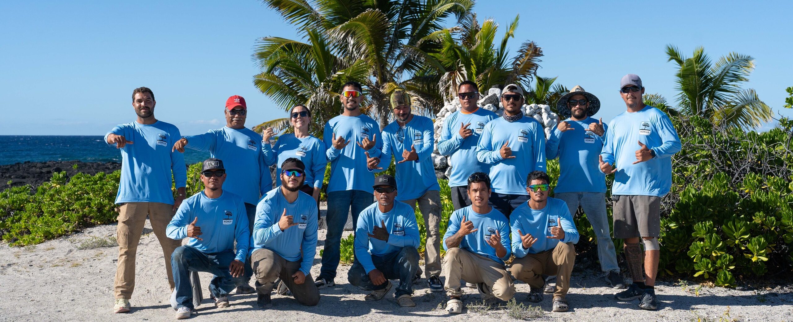 Group photo of Kokua Roofing workers on the beach