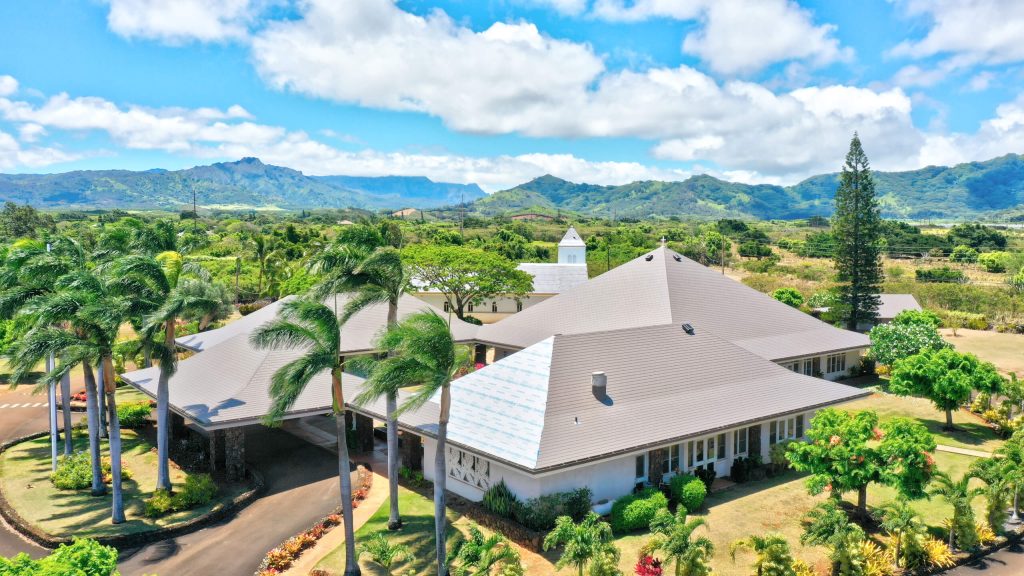 A beautiful home in hawaii surrounded by plants an trees.